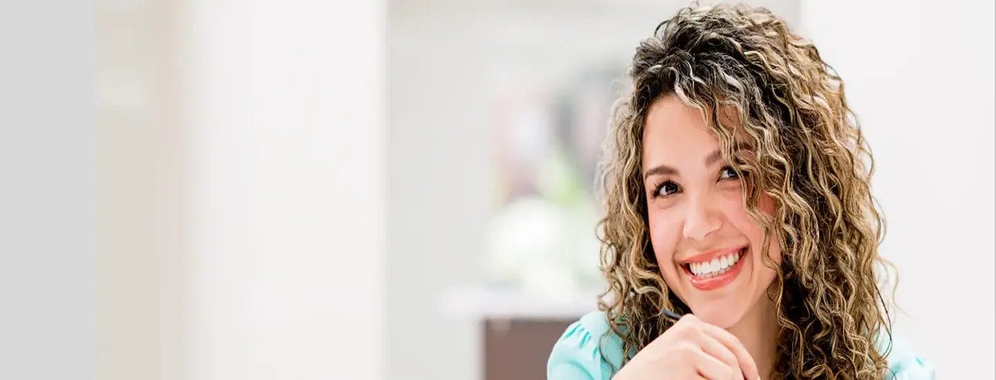 Woman smiling while wearing stylish eyeglasses